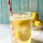 a mason jar filled with refreshing state fair lemonade with a red and white striped straw