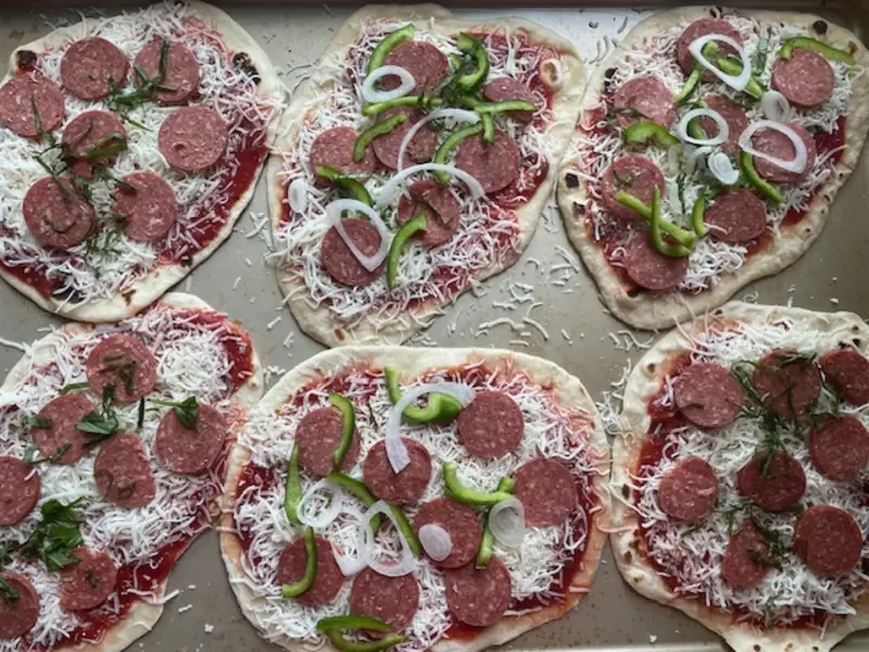 Cheesy naan bread with pepperoni, peppers and onion