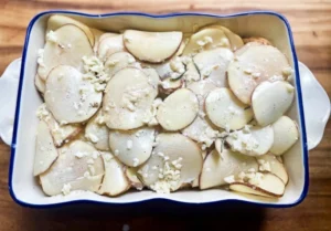 Cream mixture poured over potatoes and cheese