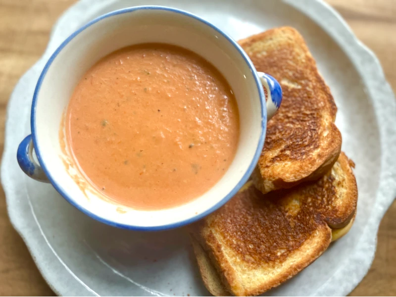 Easy Creamy Roasted Tomato Soup made with fresh garden tomatoes, onion, and garlic. A cozy, comforting soup perfect for summer harvest or chilly fall nights. Pin this recipe for delicious homemade soup to warm up with!