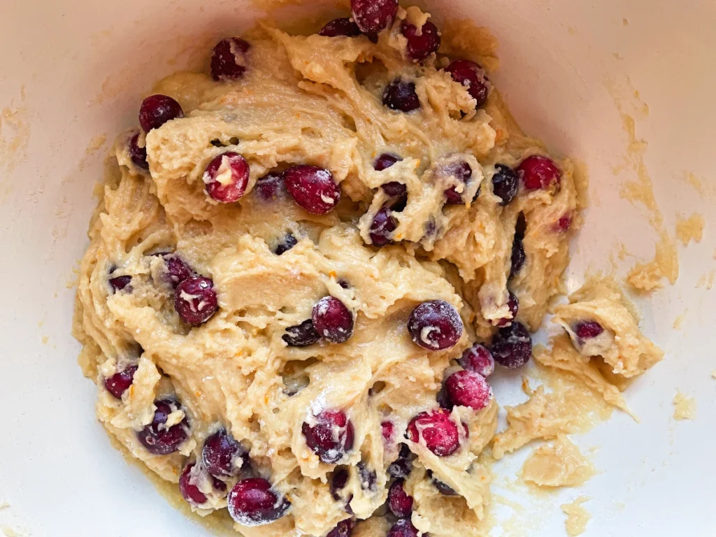 wet and dry ingredients combined with cranberries to make cranberry orange quick bread