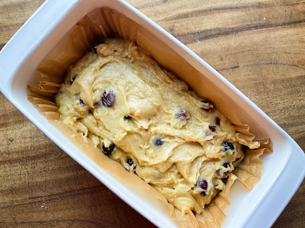batter in a baking dish for cranberry orange quick bread