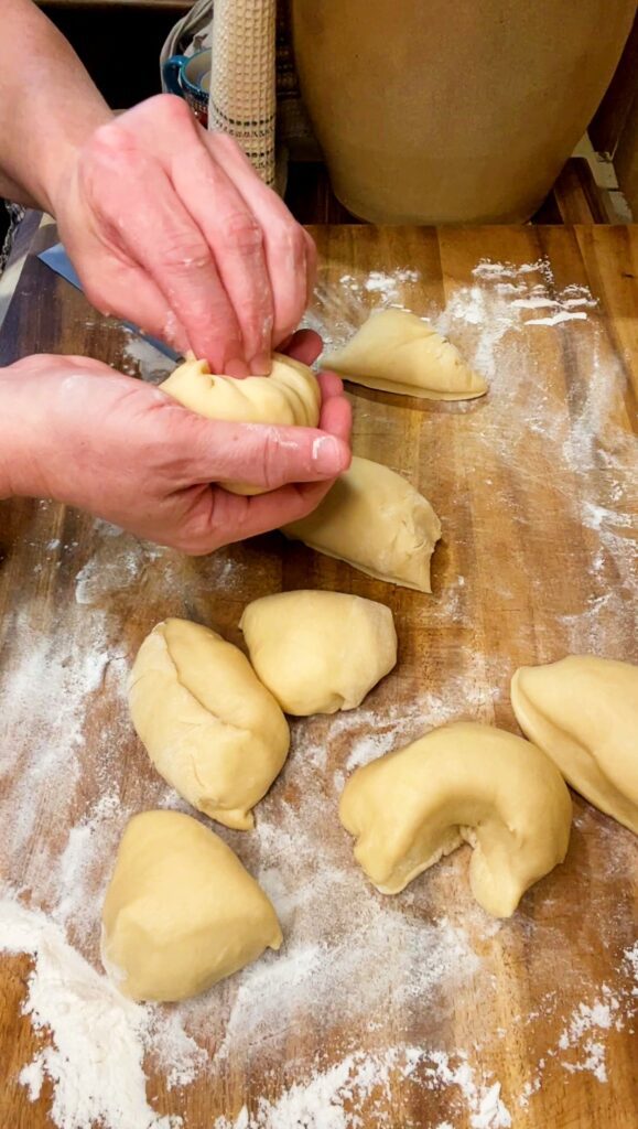 rolling dough into balls to form hamburger buns